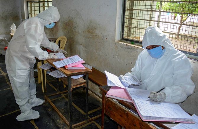 Medics wearing protective suits after collecting samples via rapid antigen kits for COVID-19 test, in Karad, on Thursday. Photograph: PTI Photo