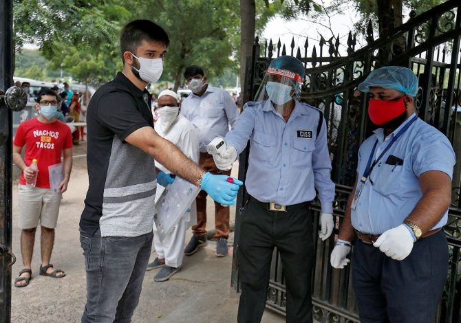 A student wearing a protective face mask gets his temperature measured as he arrives at an examination centre for NEET, in Ahmedabad. Photograph: Amit Dave/Reuters