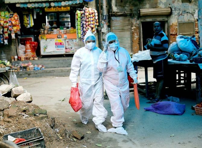 Health workers walk as they deliver pulse oximeters to people infected with the coronavirus disease in New Delhi. Photograph: Adnan Abidi/Reuters