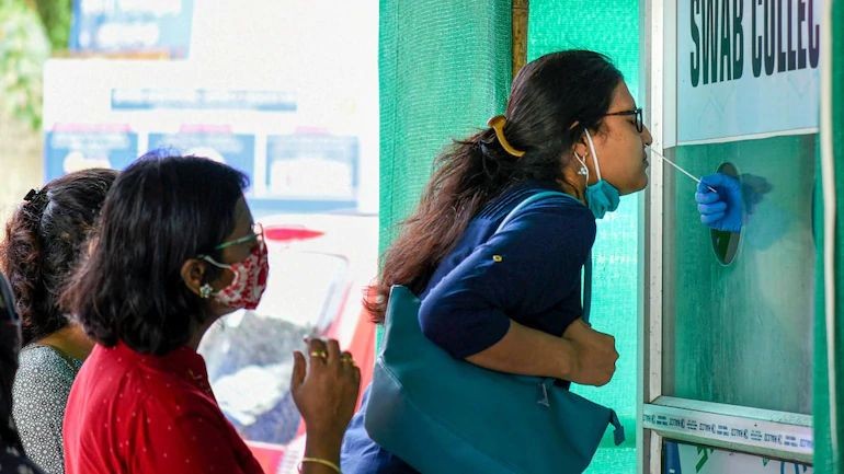 A woman giving swab sample for Covid-19 test at a collection centre in Guwahati. (Photo: PTI)