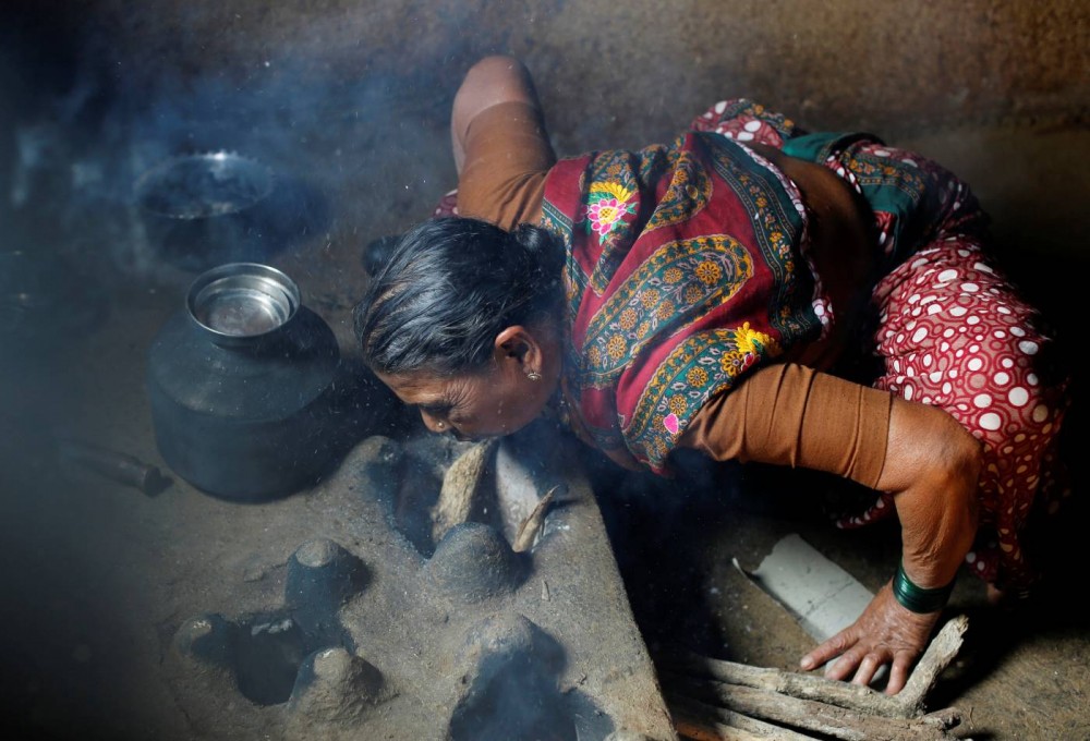 Kamal Keshavtupange, 60, lights a fire as she cooks food on a stove inside her house in Fangane village, India, February 15, 2017. REUTERS/Danish Siddiqui