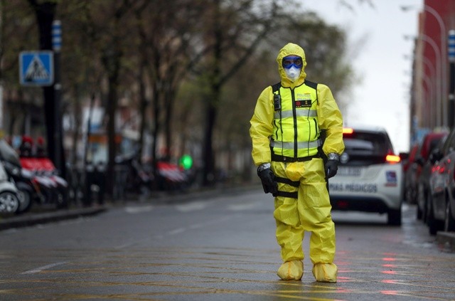 A member of the Emergency Military Unit waits for a bus in which patients infected with the COVID-19 are being transferred in Madrid, Spain. Reuters