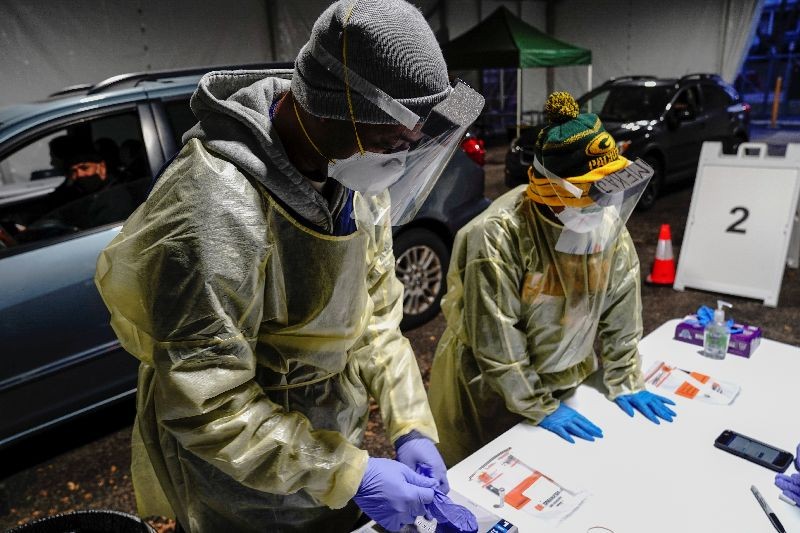 Certified nursing assistants (CNAs) Jermaine LeFlore and Shameka Johnson (right, in NFL Green Bay Packers apparel) process nasal swab samples at a drive-thru testing site outside the Southside Health Center as the coronavirus disease (COVID-19) outbreak continues in Milwaukee, Wisconsin, U.S., October 21, 2020. REUTERS/Bing Guan