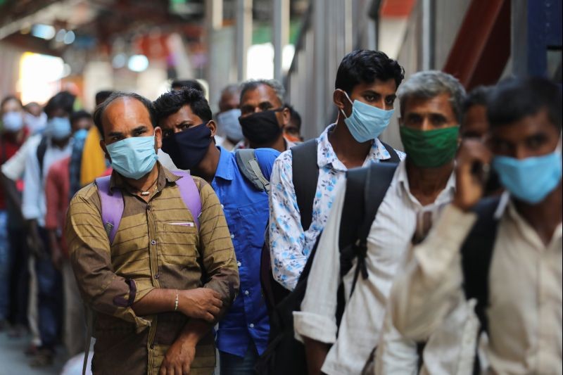 Passengers wearing protective face masks stand in a queue on a platform to get tested for the coronavirus disease (COVID-19), at a railway station, in New Delhi, India, October 5, 2020. REUTERS/Anushree Fadnavis
