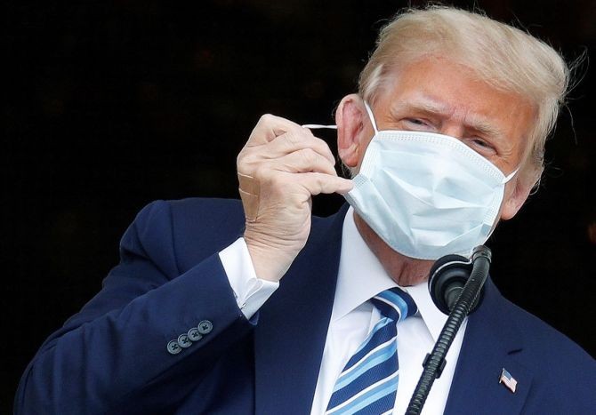 US President Donald Trumpmtakes off his face mask as he comes out on a White House balcony to speak to supporters gathered on the South Lawn for a campaign rally that the White House is calling a "peaceful protest" in Washington. Photograph: Tom Brenner/Reuters