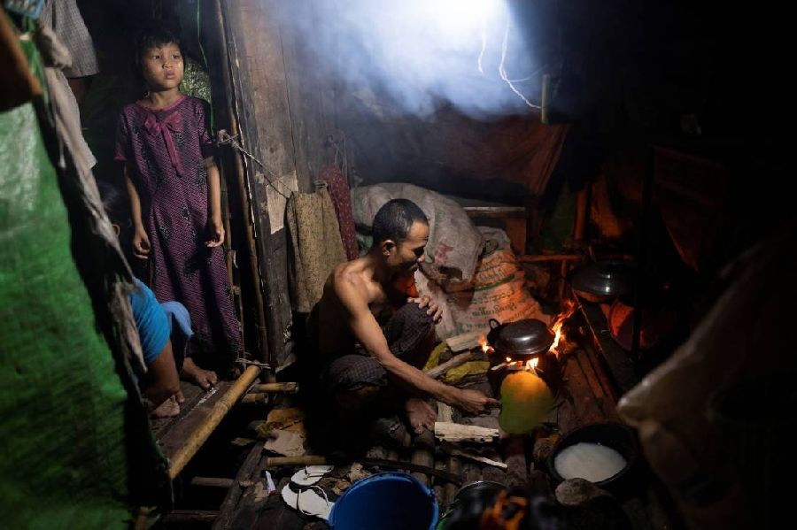 A man cooks dinner for his family in a shanty dwelling during lockdown to slow the spread of coronavirus infections in Yangon, Myanmar, October 21, 2020. REUTERS/Shwe Paw Mya Tin