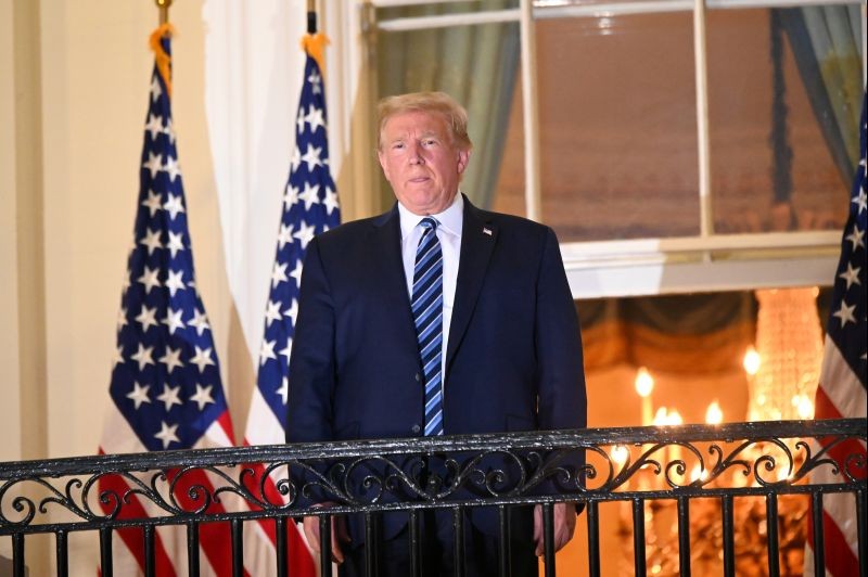 U.S. President Donald Trump poses atop the Truman Balcony of the White House after taking off his protective face mask as he returns to the White House after being hospitalized at Walter Reed Medical Center for coronavirus disease (COVID-19) treatment, in Washington, U.S. October 5, 2020. REUTERS/Erin Scott