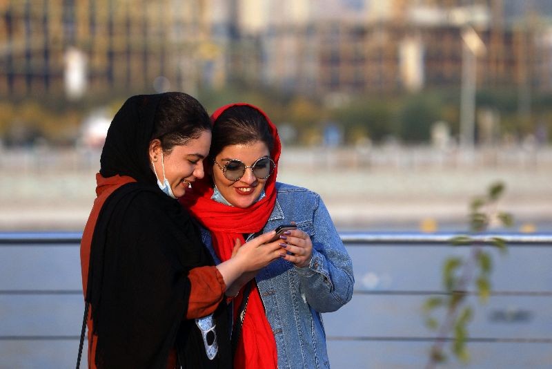 Iranian women use mobile phone, amid a rise in the coronavirus disease (COVID-19) infections, West of Tehran, Iran October 23, 2020. Picture taken October 23, 2020. Majid Asgaripour/WANA (West Asia News Agency) via REUTERS