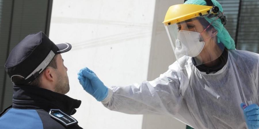 A handout picture released by the Madrid City Hall shows a health worker handling a swab to test a municipal police officer for the COVID-19 coronavirus in Madrid. (Photo | AFP)