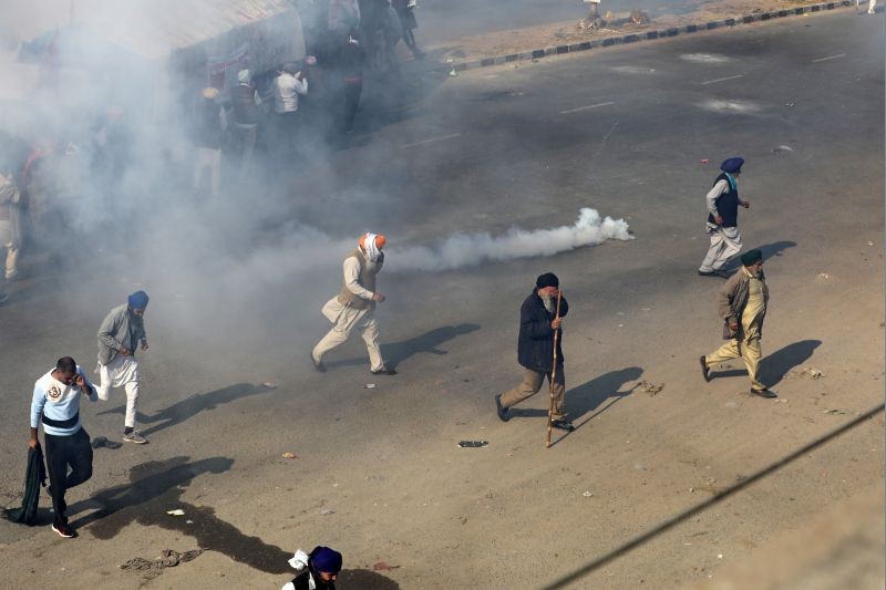 People move away from tear gas as farmers protest against the newly passed farm bills at Singhu border near Delhi, India, November 27, 2020. REUTERS/Anushree Fadnavis