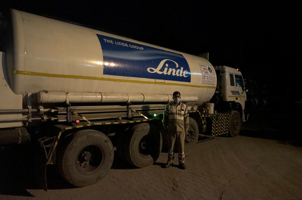 Subhas Kumar Yadav, a truck driver who ferries liquid oxygen from a Linde India factory to hospitals, poses in front of a tanker carrying liquid oxygen along a road in Selaqui in the Dehradun district of the northern state of Uttarakhand, India October 29, 2020. Picture taken October 29, 2020. REUTERS/Devjyot Ghoshal