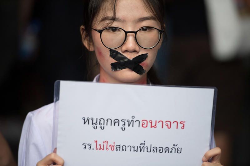 Nalinrat Tuthubthim, 20, a student, who claims she was sexually abused by a teacher, has her mouth covered with tape as pro-democracy protesters demanding the resignation of Thailand's Prime Minister Prayut Chan-o-cha and reforms on the monarchy gather during a rally in Bangkok, Thailand November 21, 2020. Picture Taken November 21, 2020. REUTERS/Chalinee Thirasupa