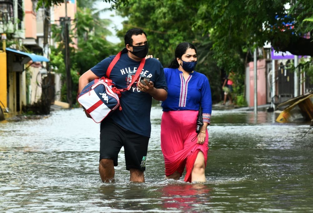 People wade through a water-logged road after Cyclone Nivar's landfall, in Chennai, India, November 26, 2020. REUTERS/P. Ravikumar