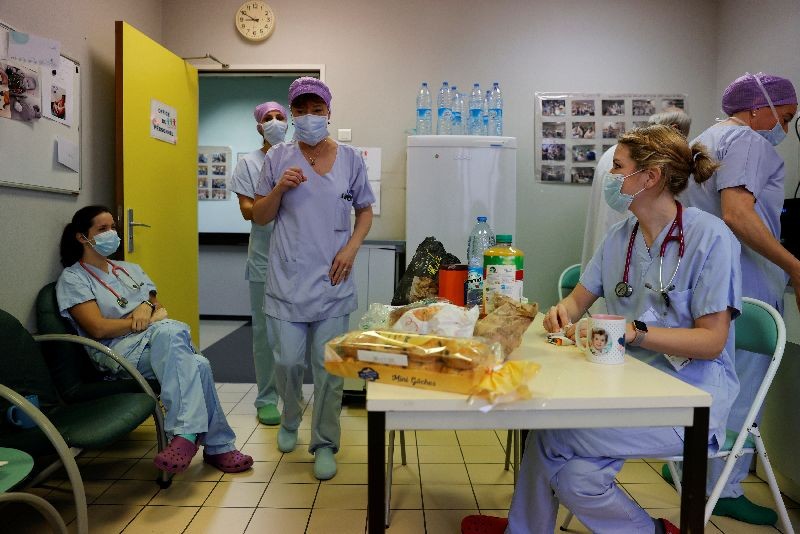 French anaesthesiologist Caroline Tesse, 34, has breakfast with colleagues in the rest room in the Intensive Care Unit (ICU) where people suffering from the coronavirus disease (COVID-19) are treated at Cambrai hospital, France, November 14, 2020. Picture taken November 14, 2020. REUTERS/Pascal Rossignol