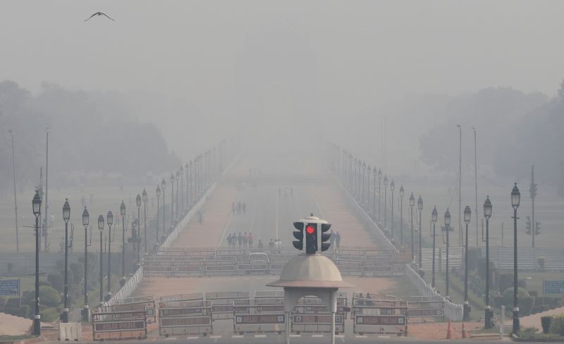 People walk near India Gate on a smoggy afternoon in New Delhi, November 15, 2020. REUTERS/Adnan Abidi