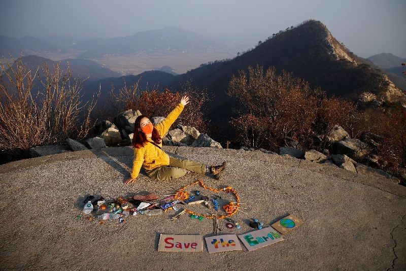 Kim Kang-Eun, an artist who leads Clean Hikers, poses artwork made from litter collected by members of Clean Hikers during their hikes, on the peak of a mountain in Incheon, South Korea, November 16, 2020. Picture taken November 16, 2020. REUTERS/Kim Hong-Ji
