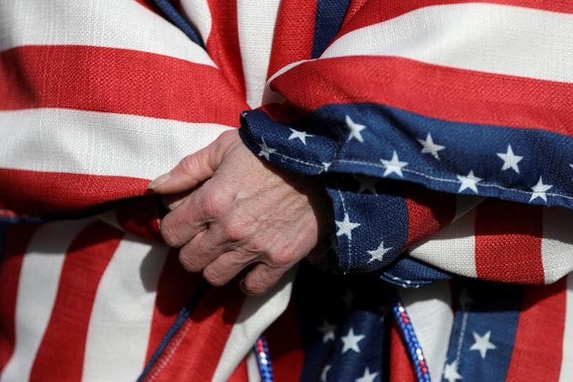 FILE PHOTO: A supporter of U.S. President Donald Trump wearing the colors of the U.S. flag participates in a "Stop the Steal" protest after the 2020 U.S. presidential election was called for Democratic candidate Joe Biden, in Lansing, Michigan, U.S. November 14, 2020. REUTERS/Emily Elconin/File Photo