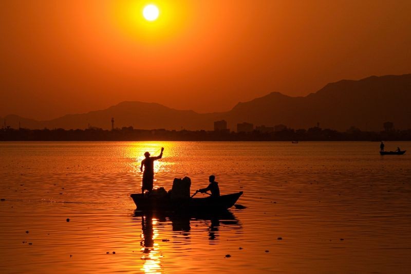 Ajmer: Fishermen silhouetted against the setting sun in the Anasagar Lake, in Ajmer, Tuesday, Dec. 22, 2020. (PTI Photo)