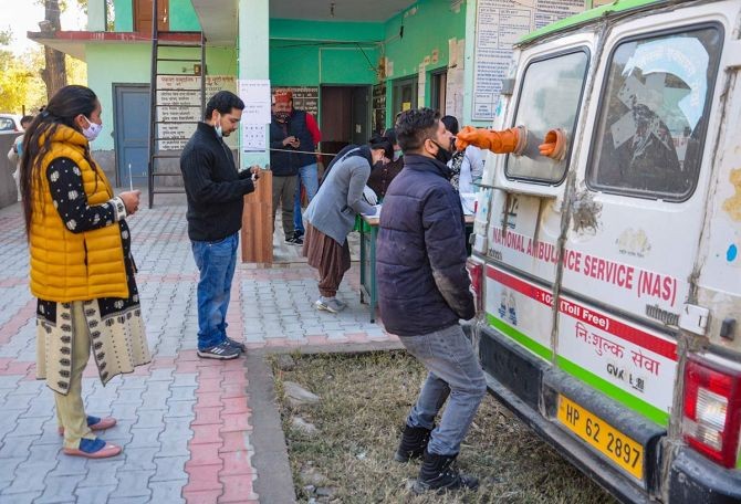 Health department workers take samples for COVID-19 tests, at a village in Kullu. Photograph: PTI Photo
