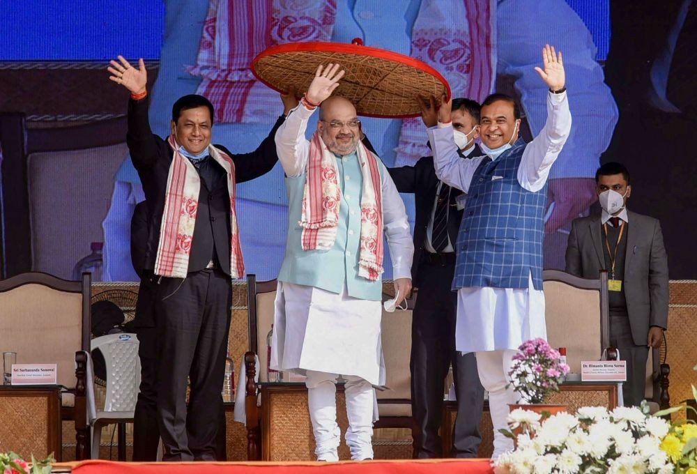 Kamrup: Union Home Minister Amit Shah being felicitated with a traditional Assamese Japi (hat) by Assam Chief Minister Sarbananda Sonowal and State Finance Minister Himanta Biswa Sharma during a programme of Assam Darshan, at Amingaon in Kamrup, Saturday, Dec. 26, 2020. (PTI Photo)