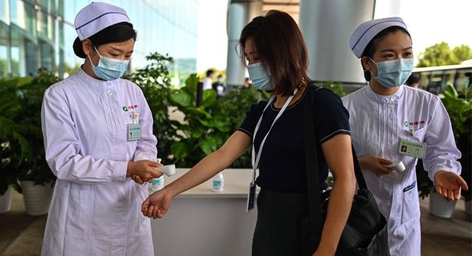 A medical worker gestures after taking the temperature of an AFP photojournalist at Tongji Hospital in Wuhan. Photo: AFP