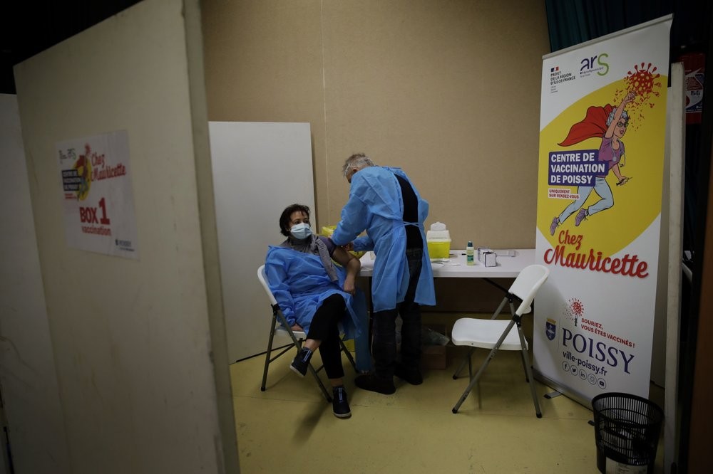 FILE - In this Jan. 8, 2021, file photo, a nurse, Ines receives a Pfizer-BioNTech COVID-19 vaccine at a coronavirus vaccine center in Poissy, France. The global death toll from COVID-19 has topped 2 million. (AP Photo/Christophe Ena, File)