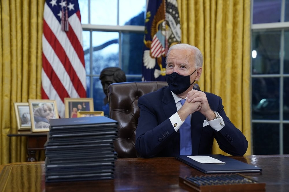 President Joe Biden waits to sign his first executive order in the Oval Office of the White House on Wednesday, Jan. 20, 2021, in Washington. (AP Photo/Evan Vucci)