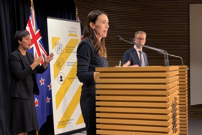 New Zealand's Prime Minister Jacinda Ardern, center, and Director-General of Health Ashley Bloomfield, right, talk to media in Wellington, New Zealand Monday, Feb. 15, 2021. As people in Auckland adjusted to a new lockdown on Monday, health officials said they'd found no evidence the coronavirus had spread further in the community, raising hopes the restrictions might be short-lived. (AP Photo/Nick Perry)