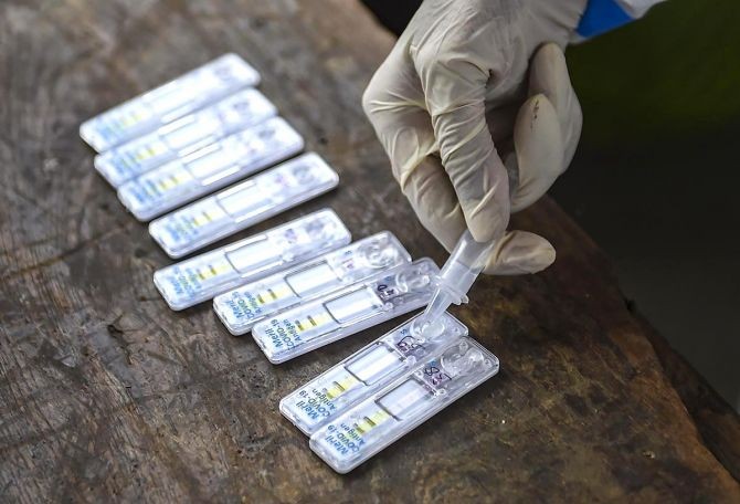 A health worker collects swab samples of passengers for COVID-19 test at Dadar railway station in Mumbai. Photograph: Kunal Patil/PTI Photo