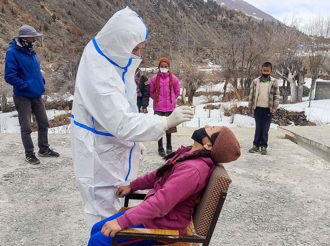 A health worker collects a sample from a teacher for COVID-19 test, at Udaipur in Lahaul-Spiti, on Wednesday. Photograph: PTI Photo