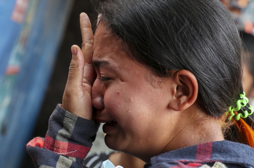 Thae Nu Naing, sister of Saw Pyae Naing weeps by his body at their home in Mandalay, Myanmar, Sunday, March 14, 2021. Saw Pyae Naing, a 21-year old anti-coup protester was shot and killed by Myanmar security forces during a demonstration on Saturday, according to his family. (AP Photo)