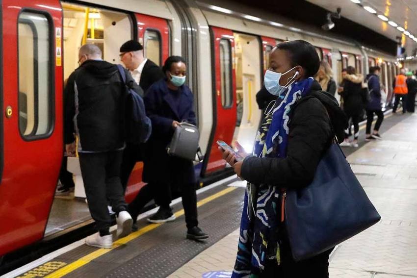 People wearing face masks to protect against the coronavirus, travel by the subway in London. AP Photo
