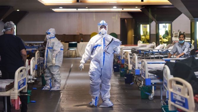 Medics attend to a COVID-19 patients at a banquet Hall, temporarily converted into an isolation ward, as coronavirus cases surge across the country. Photograph: Manvender Vashist/PTI Photo