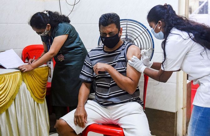 A health worker administers a dose of Covishield vaccine to the citizens at a hospital in Dharavi in Mumbai. Photograph: Shashank Parade/PTI Photo