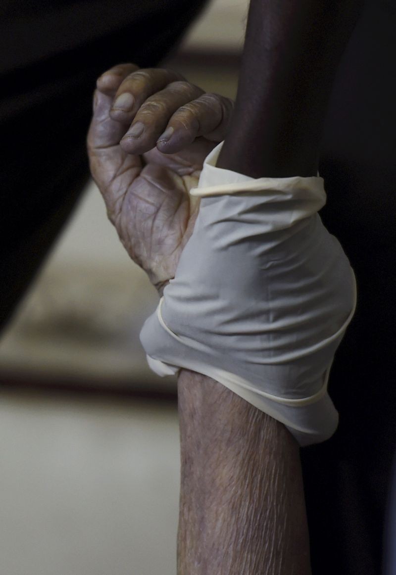 New Delhi: A Shaheed Bhagat Singh Dal volunteer wraps a COVID-19 victim  before leaving for cremation from their house, as coronavirus cases surge, at Old Seemapuri Crematoriumin in New Delhi, Friday, April 23, 2021. (PTI Photo/Manvender Vashist)
