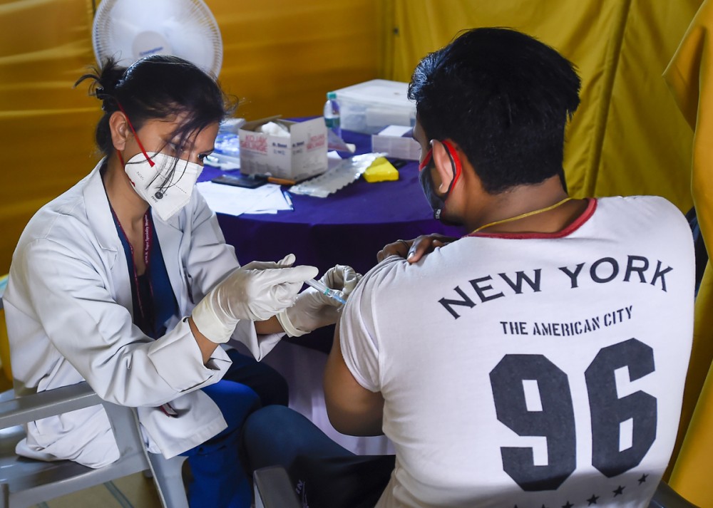 A young beneficiary receives his first dose of COVID-19 vaccine at a vaccination centre set up by BLK-Max Hospital at the Radha Soami Satsang in New Delhi. Photograph: Kamal Singh/PTI Photo