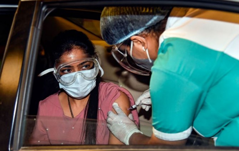 A health worker administers a dose of the COVID-19 vaccine to a woman, at a drive-through vaccination camp at Select City Walk mall, in New Delhi, on Thursday. Photograph: Kamal Singh/PTI Photo