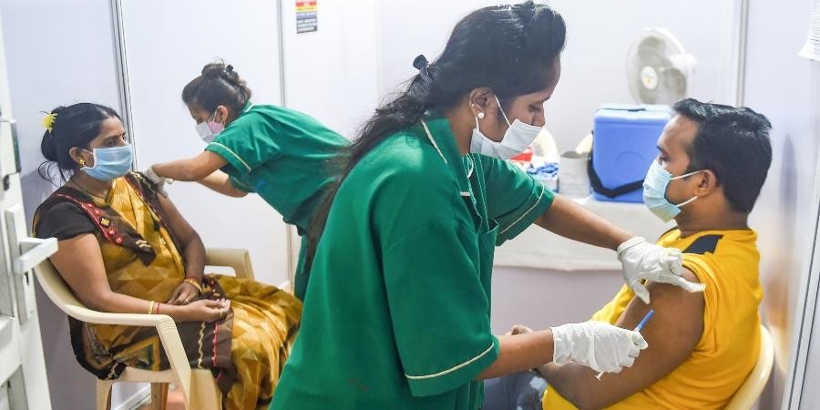 Health workers administer COVID-19 vaccine doses to beneficiaries. (Photo | PTI)