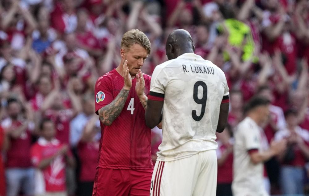 Denmark's Simon Kjaer, left, and Belgium's Romelu Lukaku clap hands as the Belgium's team pays tribute to Denmark's Christian Eriksen in 10th minute during the Euro 2020 soccer championship group B match between Denmark and Belgium at Parken stadium in Copenhagen, Denmark, Thursday, June 17, 2021. (AP Photo/Martin Meissner, Pool)