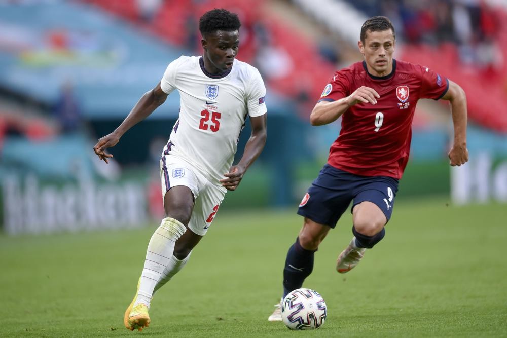 England's Bukayo Saka, left, and Czech Republic's Tomas Holes go for the ball during the Euro 2020 soccer championship group D match between Czech Republic and England, at Wembley stadium in London, Tuesday, June 22, 2021. (AP Photo/Laurence Griffiths, Pool)