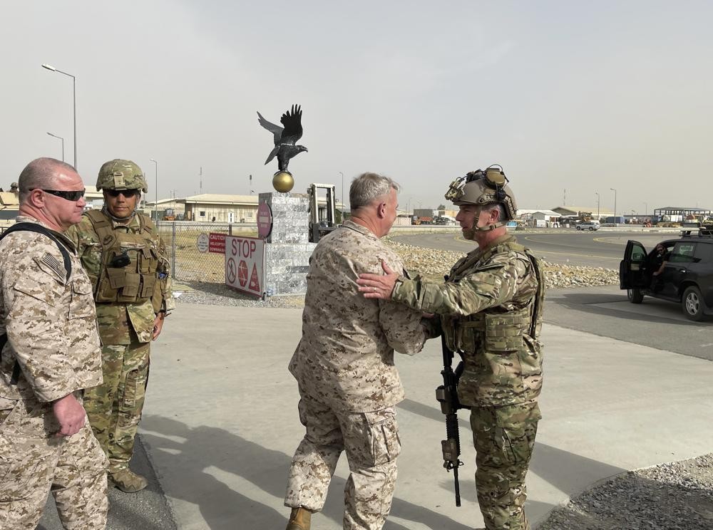 U.S. Marine Corps Gen. Frank McKenzie, center, the commander of U.S. Central Command, meets with U.S. Navy Rear Adm. Peter Vasely, commander of U.S. Forces Afghanistan-Forward, at Hamid Karzai International Airport, Kabul, Afghanistan, Tuesday, Aug. 17, 2021. (Capt. William Urban/U.S. Navy via AP)