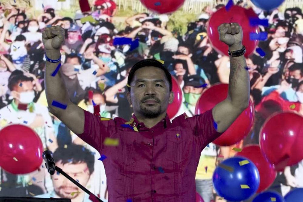In this photo provided by the Manny Pacquiao MediaComms, Senator Manny Pacquiao raises his hands during a national convention of his PDP-Laban party in Quezon city, Philippines on Sunday Sept. 19, 2021. Philippine boxing icon and senator Manny Pacquiao says he will run for president in the 2022 elections. (Manny Pacquiao MediaComms via AP)
