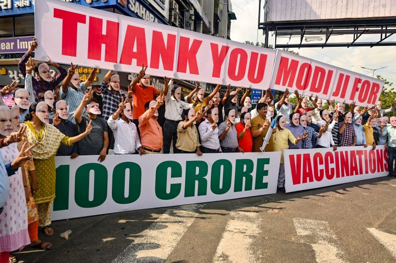 People wearing face mask of Prime Minister Narendra Modi and others celebrate 1 billion vaccine dose completion in India, in Ahmedabad on October 24, 2021. (PTI Photo)