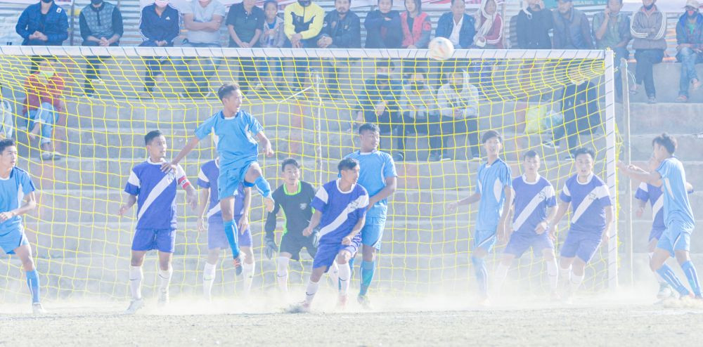 Rili & Heli FC players in blue with white stripe jersey playing against Axios FC in navy blue kit. (Morung Photo)