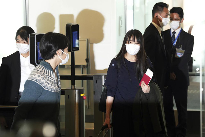 Japan's former Princess Mako, right, the elder daughter of Crown Prince Akishino, and her husband Kei Komuro, left, walk to board an airplane to New York on November 14, 2021, at Tokyo International Airport in Tokyo. (AP Photo)