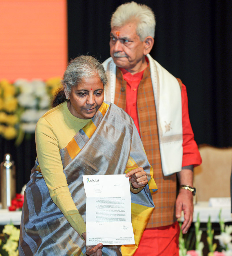 Union Finance Minister Nirmala Sitharaman along with LG J&K Manoj Sinha handover 200 crore sanction letter to Principal Seceretary, Industries & Commerce Govt of J&K Ranjan Prakash Thakur under SIDBI cluster Development Fund during outreach programme and launch of new schemes and projects at Zoravar Singh Auditorium in Jammu on November 23, 2021. (PTI Photo)