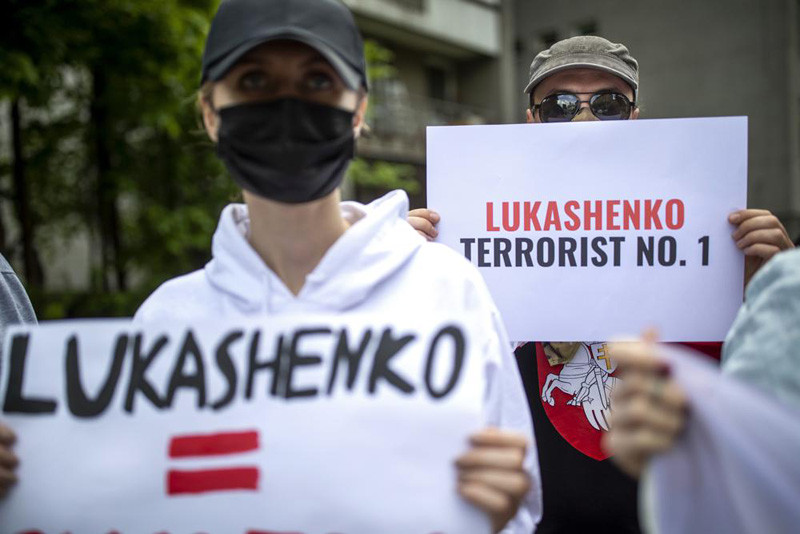 Protesters hold banners during a demonstration demanding freedom for Belarus opposition activist Raman Protasevich, in front of the U.S. Embassy in Vilnius, Lithuania, Friday, May 28, 2021. Democracy is deteriorating across the world, with countries notably taking undemocratic and unnecessary actions to contain the coronavirus pandemic, an intergovernmental body, the International Institute for Democracy and Electoral Assistance, or International IDEA, said in its new report on November 22, 2021. (AP File Photo)