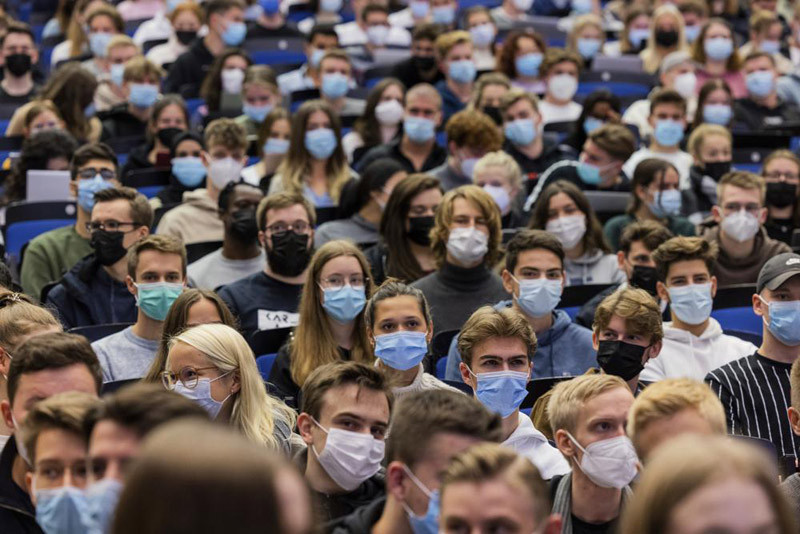 Students wear mouth-to-nose coverings while sitting close to each other during the lecture 'BWL 1' in lecture hall H1 of the Westfaelische Wilhelms-Universitaet in Muenster, Germany on October 21, 2021. Germany's disease control agency has reported the highest number of new infections with the coronavirus since the outbreak of the pandemic. (AP File Photo)