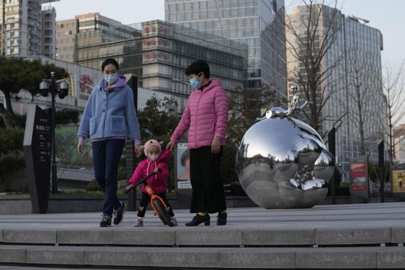 Residents wearing masks past by an art work outside a mall in Beijing, China, Saturday, Nov. 13, 2021. Quarantines, obligatory testing and travel restrictions have become a way of life for much of the population. The country's vaccination rate is among the world's highest and authorities are beginning to administer booster shots as winter descends. (AP File Photo)