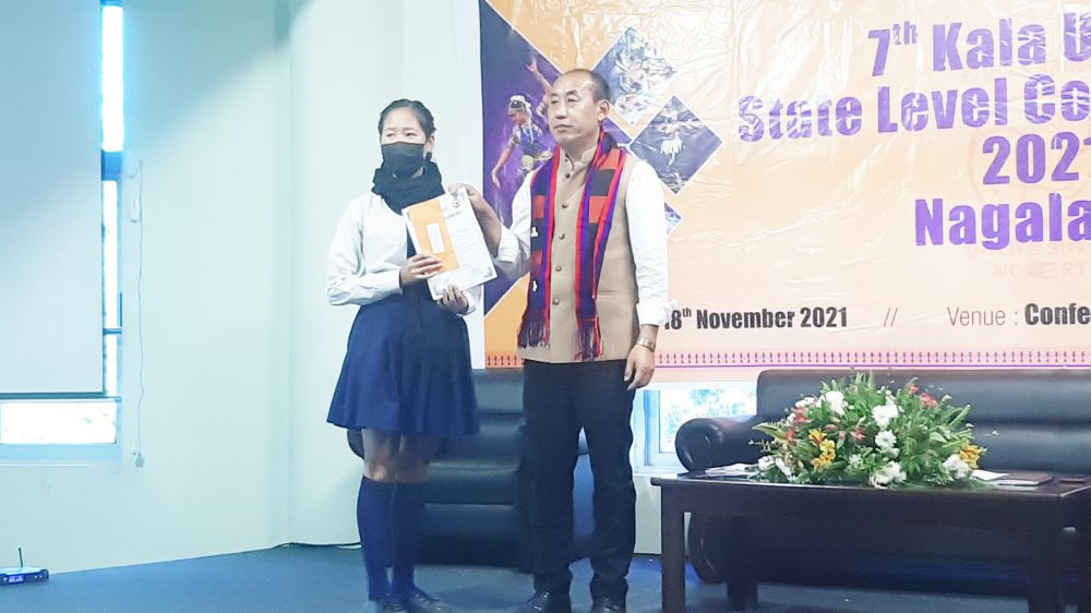 Razouseyi Vese presents prize to one of the winners of the state level online Kala Utsav competition in Kohima on November 17.